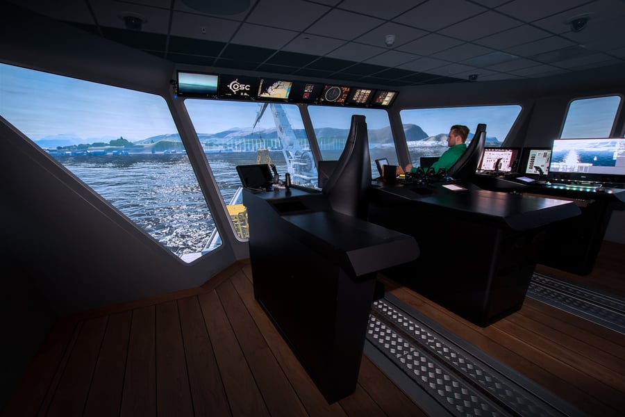 Bridge consoles with a crane vessel in the fjord outside